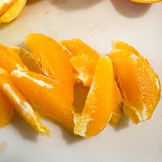 peeled oranges are sitting on a cutting board