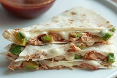 a white plate topped with a quesadilla cut in half and sitting on top of a table