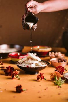 someone is pouring something into a bowl on a table