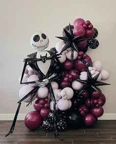 the balloon tree is made up of balloons and black, white, and pink decorations