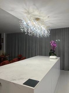 a white counter top sitting under a chandelier