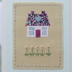 a card with a house and flowers on it