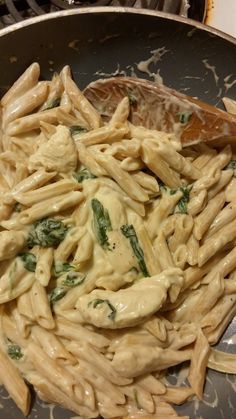 pasta with spinach and sauce in a skillet