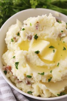 mashed red potatoes with butter and parsley in a white bowl