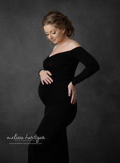 a pregnant woman poses in a black gown