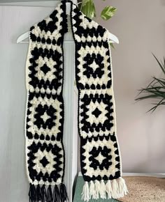 a black and white crocheted scarf hanging on a hook