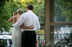 a bride and groom standing together in front of trees