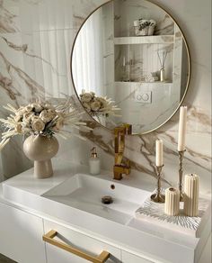 a bathroom sink with a mirror above it and candles on the counter next to it