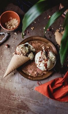 two scoops of ice cream sitting on top of a wooden plate next to a red napkin