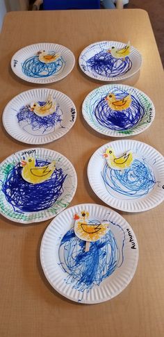 paper plates with drawings on them sitting on a table