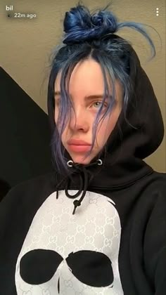 a person with blue hair wearing a skull hoodie