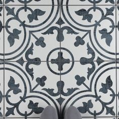 a person standing in front of a tile floor with their feet up on the ground