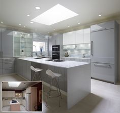 two stools are in the middle of a kitchen island with white countertops and stainless steel appliances