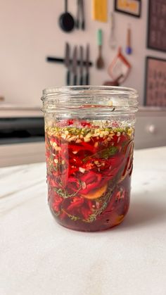 a glass jar filled with food sitting on top of a white counter next to a wall