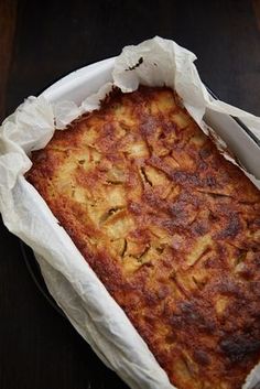 a square casserole in a white dish on a wooden table with a fork