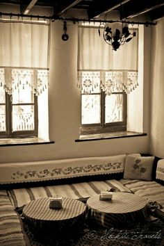 a living room filled with furniture and two windows