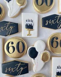 decorated cookies with black and gold icing are arranged in the shape of 60th birthday cakes