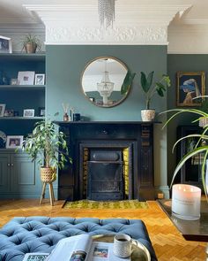 a living room filled with furniture and a fire place in front of a mirror on the wall