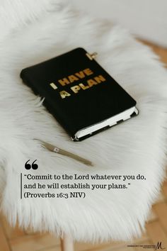 a bible sitting on top of a white fur covered floor next to a pen and knife