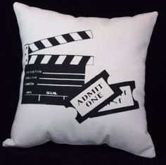 a white pillow with black and white movie clappers on it, against a black background