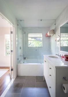 a bathroom with a sink, toilet and bathtub next to a window in it