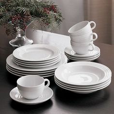 a table topped with white plates and cups