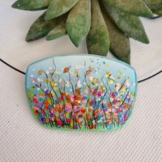 a painted rock sitting on top of a table next to a plant