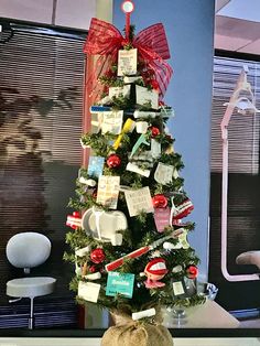 a small christmas tree decorated with tags and bows