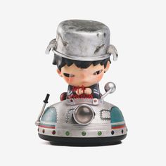 a little boy with a silver hat on top of a small toy car that is shaped like a submarine