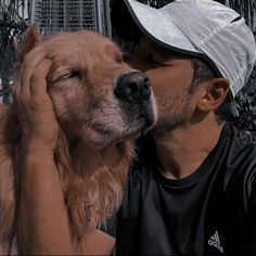 a man is holding his dog in front of him and he has his head on his face