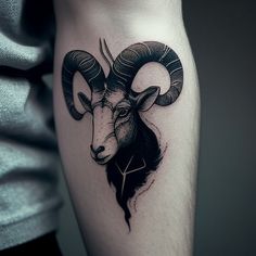 a black and white photo of a ram tattoo on the arm