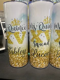 three cups with gold glitter on them sitting on a table