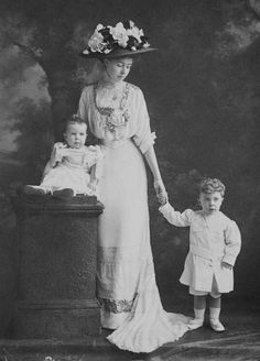 an old black and white photo of a woman with two children