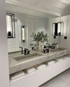 a large bathroom with two sinks and mirrors