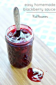 homemade blackberry sauce in a glass jar with spoon