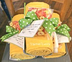 a stack of yellow towels sitting on top of a wooden chair covered in green polka dots