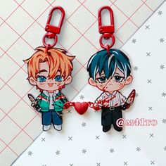 two key chains with anime characters on them, one is holding the other's hand