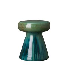 a green and white vase sitting on top of a table