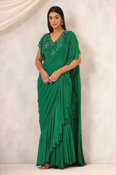 Green pre-draped saree with a delicately embroidered border and frill details on the border and pallu. Paired with a padded embroidered blouse in floral pattern. - Aza Fashions Georgette Pre-draped Saree For Designer Wear, Designer Green Pre-draped Saree With Embroidered Border, Traditional Drape Sharara With Embroidered Border For Reception, Festive Green Pre-draped Saree With Embroidered Border, Festive Green Pre-draped Saree With Ruffles, Elegant Pre-draped Saree With Ruffles For Navratri, Georgette Saree With Cutdana Detailing, Georgette Saree With Cutdana, Draped Style, Cutdana Embellished Draped Georgette Saree