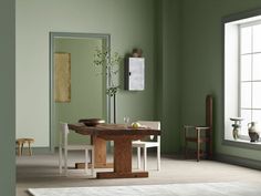 a dining room with green walls and white furniture