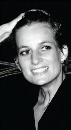 a black and white photo of a woman with her hair in a bun smiling at the camera