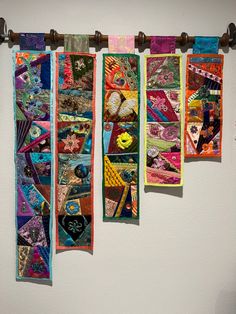 three pieces of colorful fabric hanging on a wall