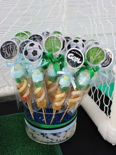 a cupcake arrangement in a plastic container with soccer stickers on it and green bows