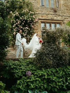 a bride and groom walking down the steps to their wedding ceremony in front of an old stone building