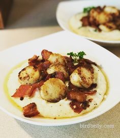 two white plates filled with food on top of a table