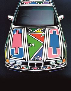 the front end of a car painted with multicolored designs