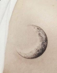 a crescent moon tattoo on the right shoulder