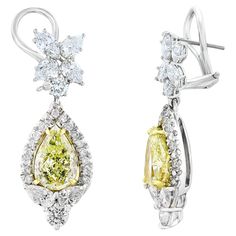 A beautiful and chic pair of drop earrings showcasing a cluster of brilliant mixed-cut diamonds, and pear-shaped brilliant yellow diamonds set in an intricate and stylish design. 10 Mixed cut Diamonds weigh 1.91 carats in total. 2 yellow diamonds weigh 3.79 carats in total. They are made in 18k white gold. 44 accent diamonds weigh 0.83 carats in total. The color of these gemstones is ideal, with great luster/shine. Omega clasp with a post. Yellow Diamonds, Fancy Yellow Diamond, Crocodile Bags, Diamond Drop Earrings, Diamond Drops, Cute Relationship Goals, Yellow Diamond, High Jewelry, Stylish Design