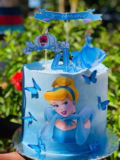 there is a blue cake with a princess on it