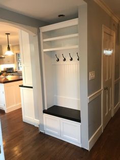 an empty room with white cabinets and black bench